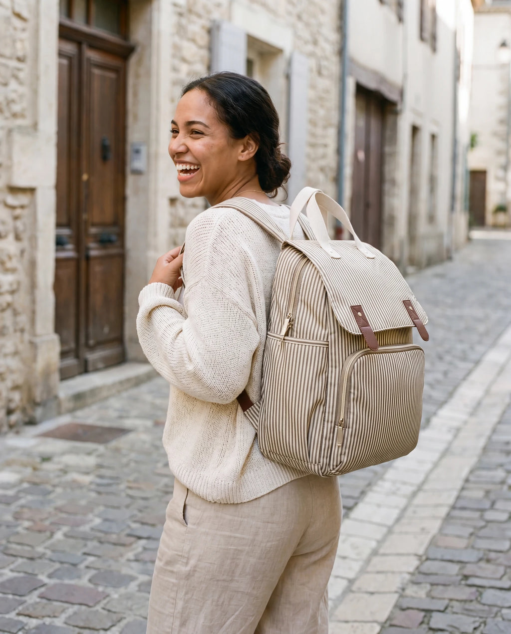 Maman portant le sac à dos à langer rayé beige en ville