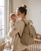 Maman et bébé avec le sac à dos à langer rayé beige