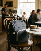 Sac à dos à langer bébé maternité matelassé Tendrinette · Gris anthracite · posé sur une chaise de café