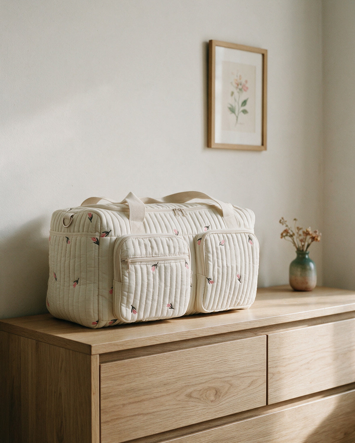 Sac à langer maternité matelassé brodé Tendrinette · Tulipes brodées · posé sur une commode dans la chambre de bébé
